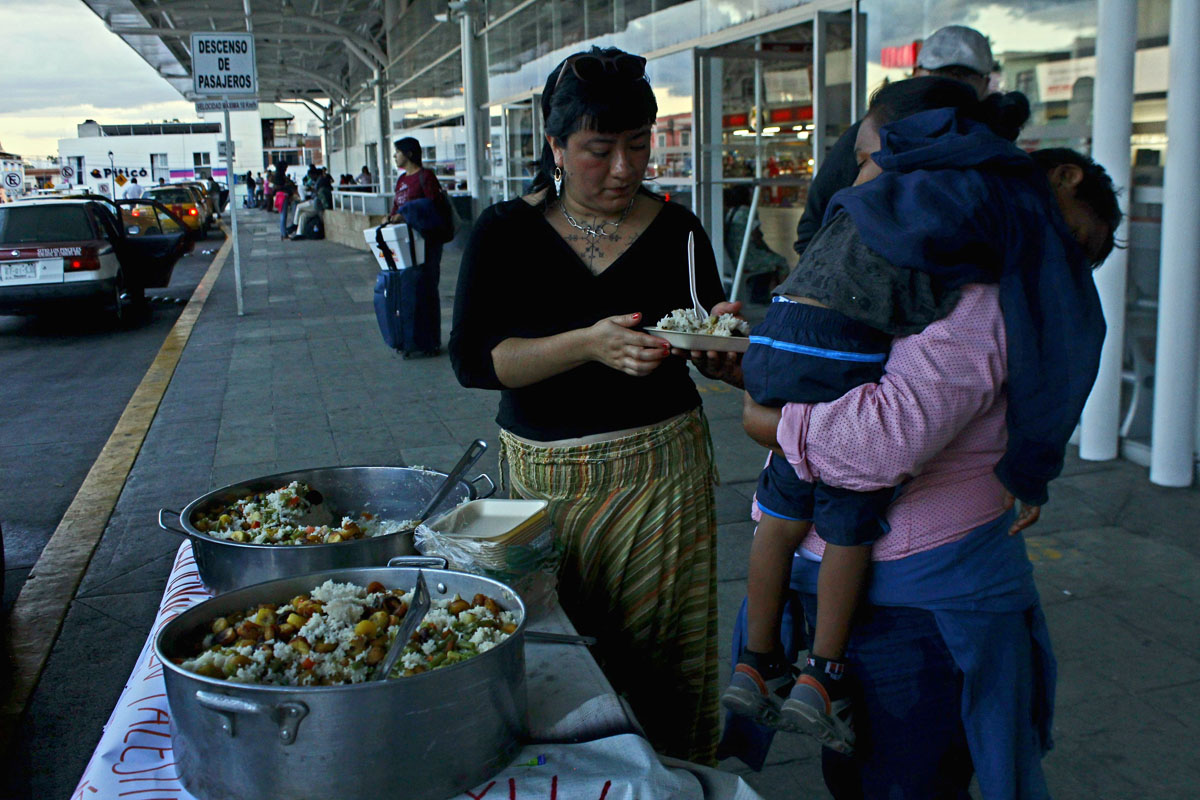 Integrantes de la comedora ‘‘Nkä'äymyujkëmë’’ reparten alimentos a población migrante en tránsito, en la central de Autobuses Unidos de Oriente, Oaxaca de Juárez. Crédito: Metztli Molina Olmos